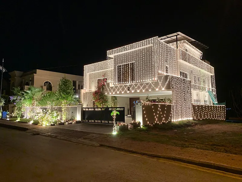 House front covered in string lights for a wedding, Islamabad